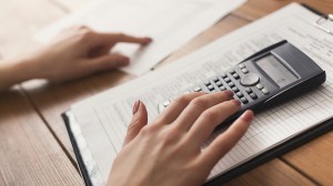 Closeup of woman hands counting on calculator